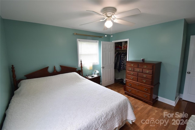 bedroom with a closet, baseboards, wood finished floors, and a ceiling fan