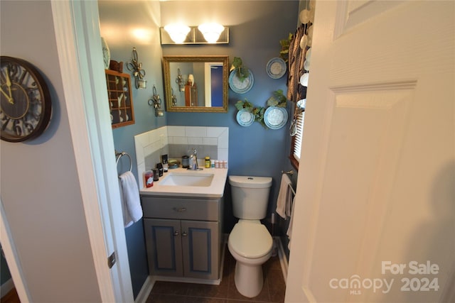 bathroom featuring vanity, tile patterned floors, toilet, and tasteful backsplash