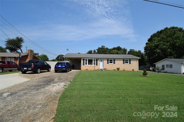 ranch-style home featuring an attached carport, a front yard, brick siding, and driveway