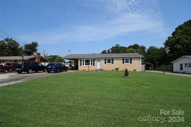 single story home featuring a carport, concrete driveway, a front yard, and brick siding