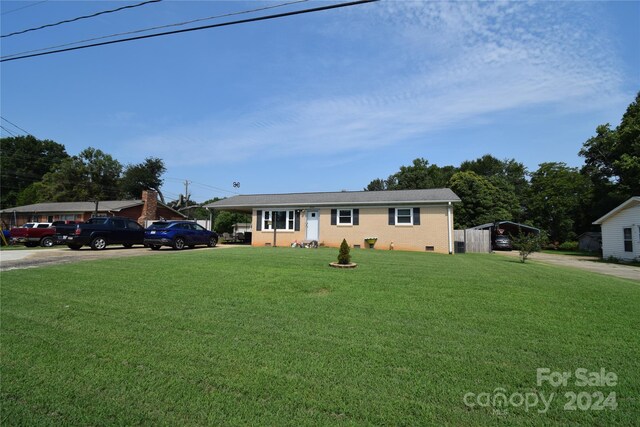 ranch-style home featuring a front yard, concrete driveway, a carport, and brick siding