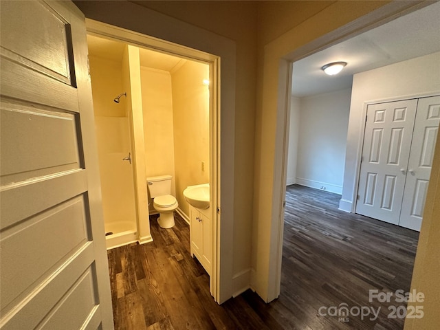 hall featuring dark wood-type flooring and baseboards