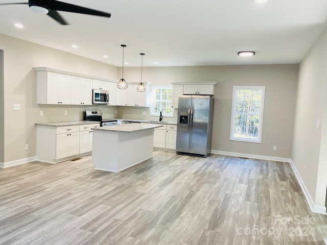 kitchen featuring a healthy amount of sunlight, pendant lighting, a center island, and stainless steel appliances