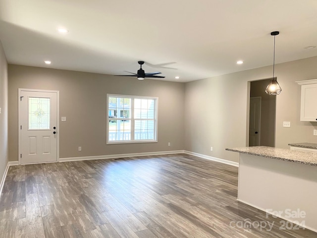 unfurnished living room featuring ceiling fan, dark wood-style flooring, recessed lighting, and baseboards