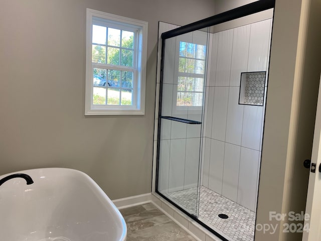 full bath with a sink, a stall shower, baseboards, and a freestanding bath