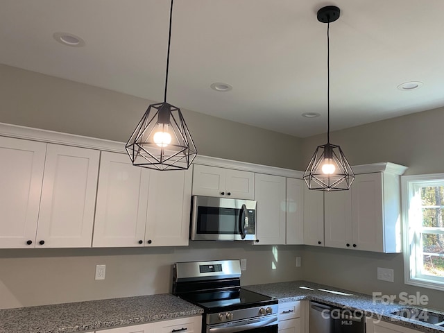 kitchen featuring recessed lighting, hanging light fixtures, appliances with stainless steel finishes, white cabinets, and a sink