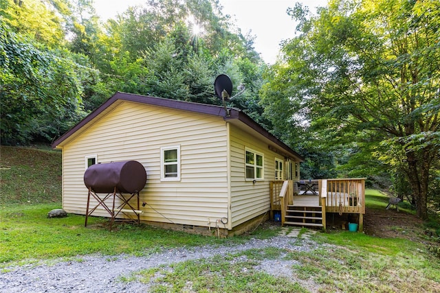 view of side of property featuring a yard and a deck