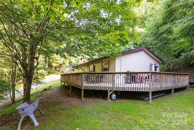 rear view of property with a lawn and a deck