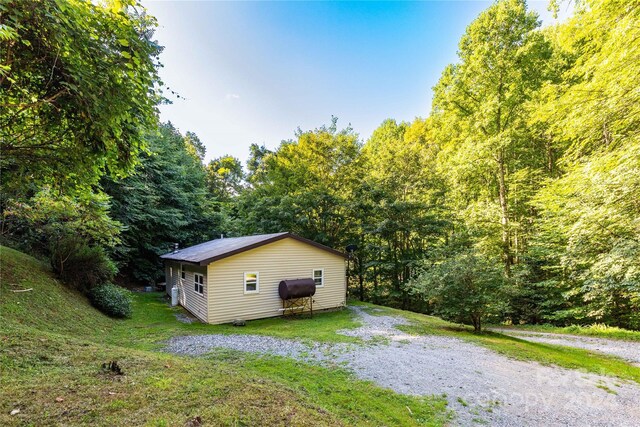 view of side of home featuring a yard and an outdoor structure