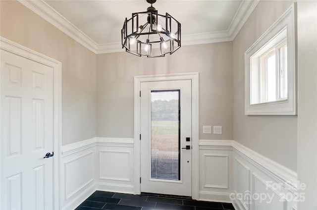 doorway with dark tile patterned flooring, plenty of natural light, crown molding, and a chandelier