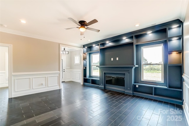 unfurnished living room with ceiling fan with notable chandelier and ornamental molding