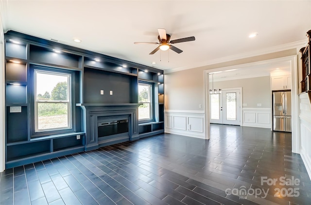 unfurnished living room featuring ceiling fan and crown molding