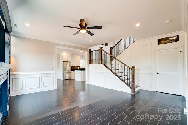 unfurnished living room with ceiling fan, dark hardwood / wood-style flooring, and ornamental molding