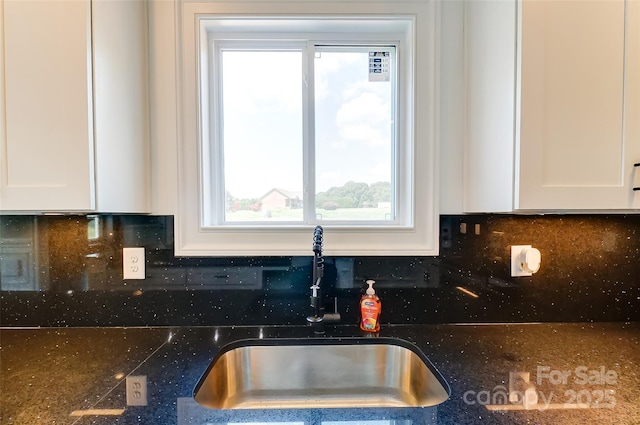 kitchen with white cabinetry, sink, and tasteful backsplash