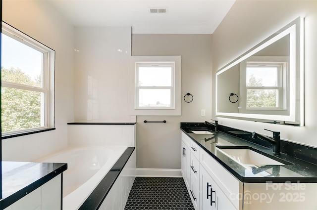 bathroom featuring a bathing tub, tile patterned flooring, and vanity