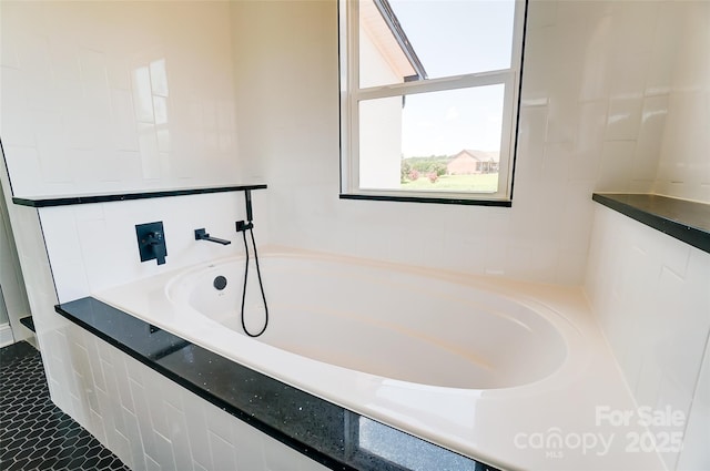 bathroom featuring tile patterned flooring and tiled bath