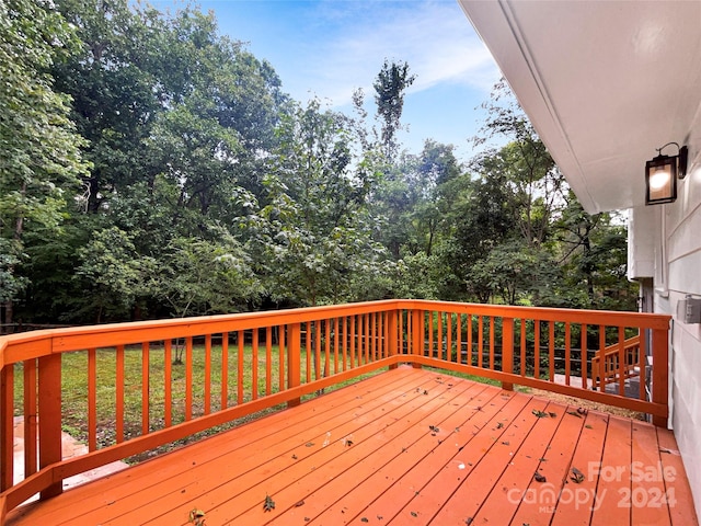 wooden terrace with a lawn