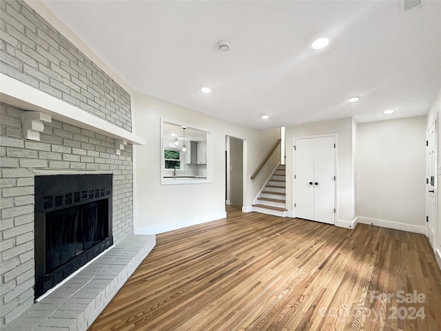 unfurnished living room featuring a fireplace and hardwood / wood-style flooring