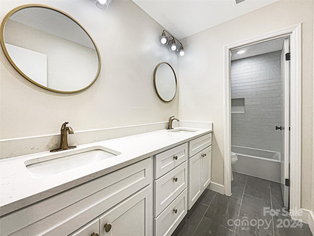 full bathroom featuring tiled shower / bath, double vanity, toilet, and tile patterned flooring