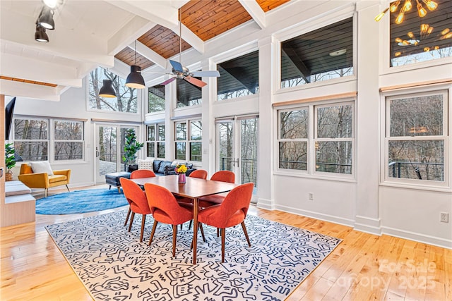 sunroom featuring beam ceiling, wooden ceiling, and ceiling fan