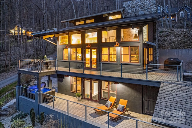 rear view of property featuring a balcony and a patio