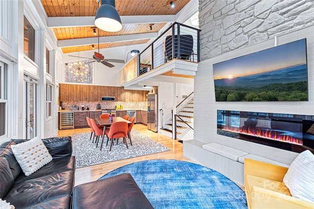 living room with beam ceiling, high vaulted ceiling, wine cooler, a fireplace, and wooden ceiling