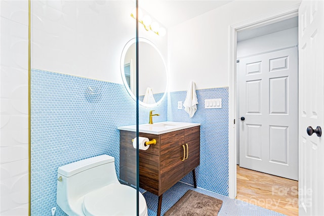 bathroom featuring tile walls, vanity, tile patterned floors, and toilet