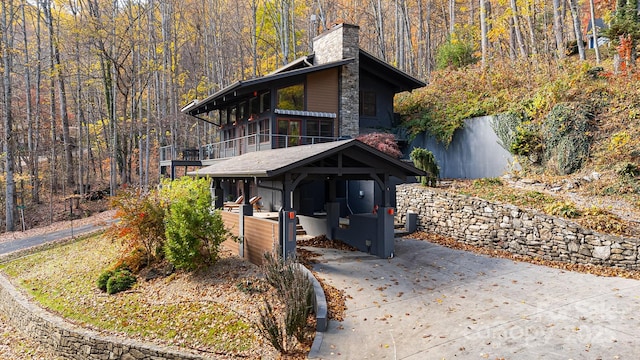 view of side of home featuring cooling unit, a sunroom, and a carport