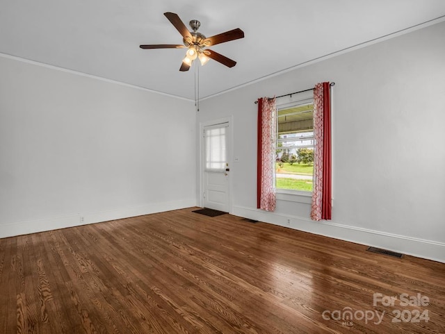 empty room featuring ceiling fan, crown molding, and wood-type flooring