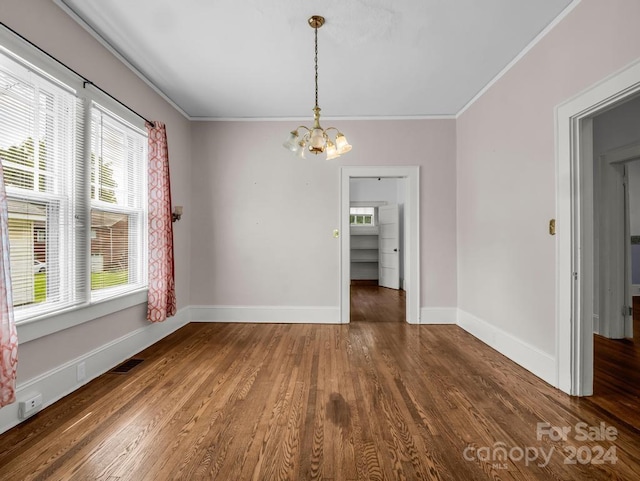 unfurnished dining area featuring a notable chandelier, ornamental molding, and hardwood / wood-style flooring