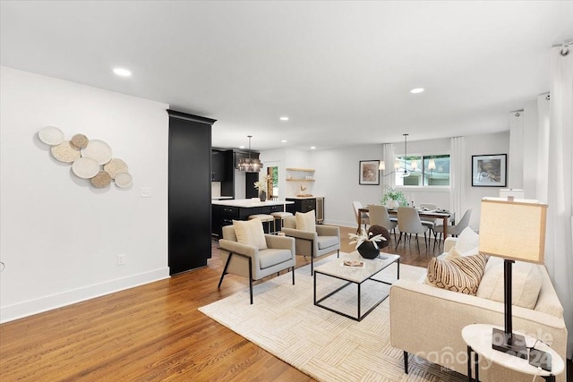 living room featuring light wood-type flooring and a chandelier