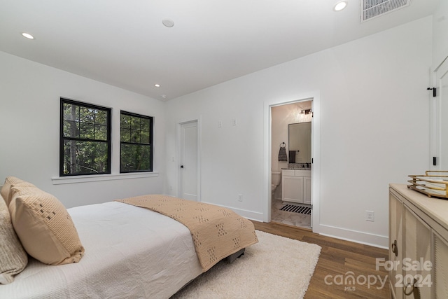 bedroom featuring dark hardwood / wood-style flooring and ensuite bathroom