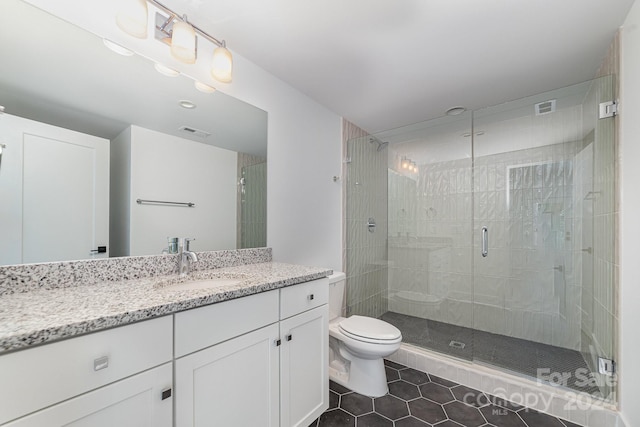 bathroom featuring tile patterned flooring, an enclosed shower, vanity, and toilet