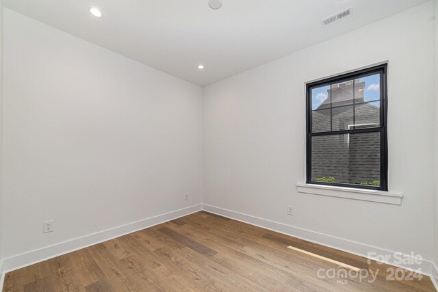 unfurnished room featuring hardwood / wood-style flooring and a healthy amount of sunlight