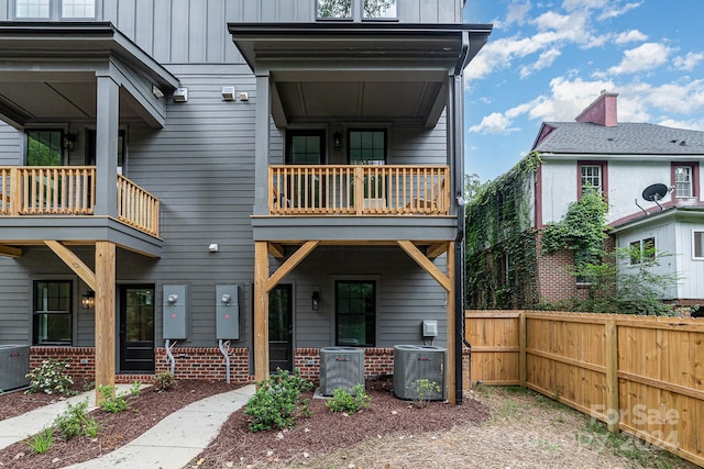 back of house with central air condition unit and a balcony