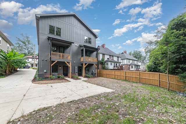 rear view of property featuring a balcony and cooling unit