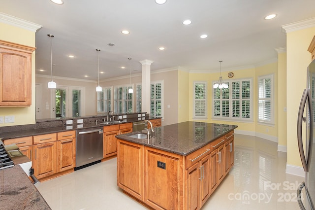 kitchen featuring appliances with stainless steel finishes, ornamental molding, a kitchen island with sink, sink, and pendant lighting