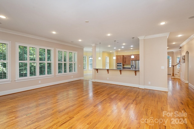 unfurnished living room featuring crown molding and light wood-type flooring