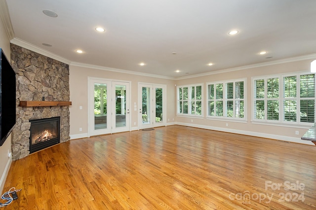 unfurnished living room featuring a fireplace, light hardwood / wood-style floors, and crown molding