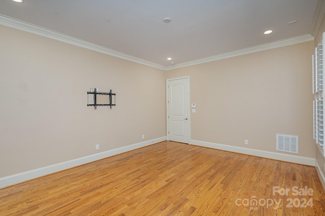 spare room featuring light hardwood / wood-style floors and ornamental molding