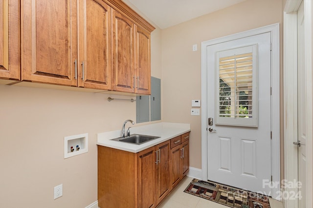 washroom with cabinets, hookup for a washing machine, light tile patterned flooring, and sink