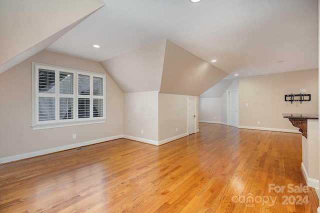 bonus room featuring light hardwood / wood-style flooring and lofted ceiling