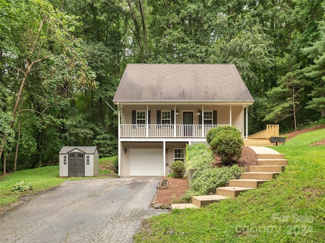 view of front of home with a porch, a garage, a front lawn, and a storage shed