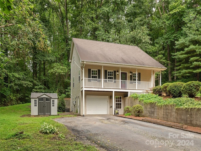 view of front of property with a porch, a garage, a front lawn, and a storage unit