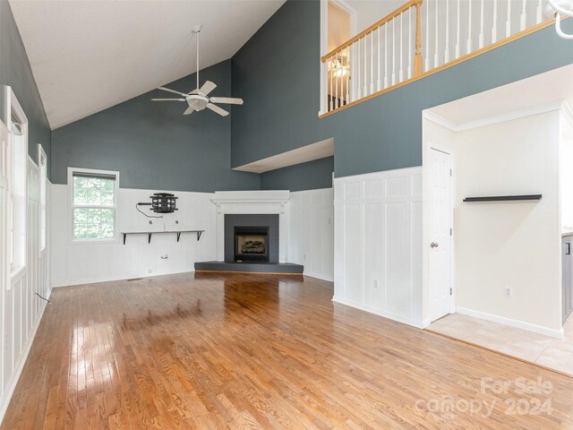 unfurnished living room featuring high vaulted ceiling, light wood-type flooring, and ceiling fan