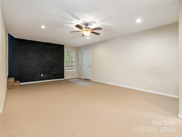 spare room featuring carpet and ceiling fan