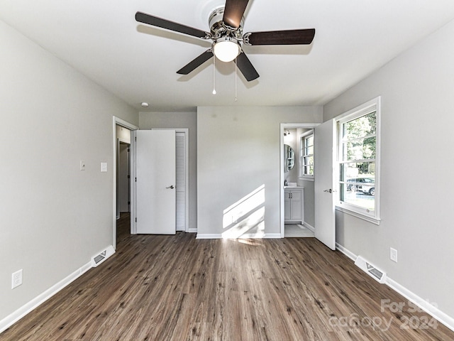 unfurnished bedroom featuring ceiling fan, a closet, hardwood / wood-style flooring, and ensuite bathroom