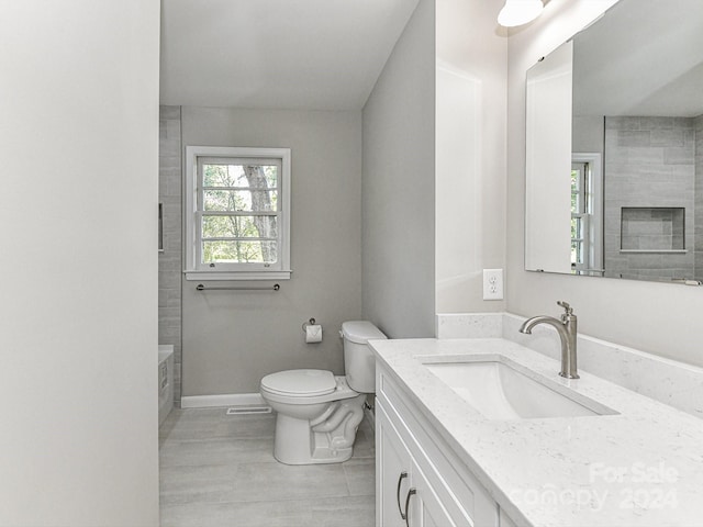 full bathroom with tiled shower / bath, a fireplace, toilet, tile patterned floors, and vanity