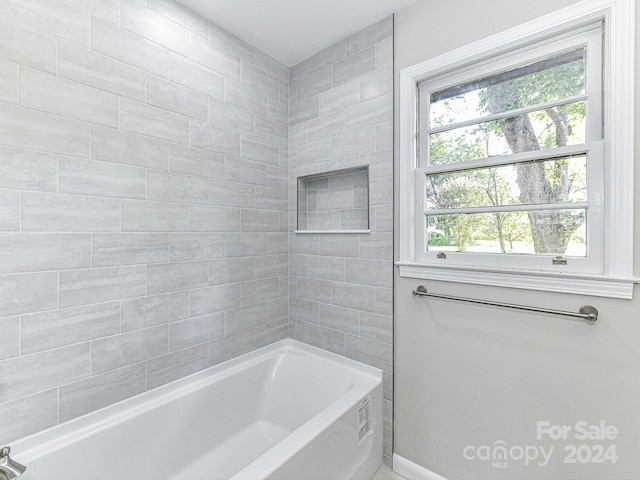 bathroom featuring tiled shower / bath combo and a wealth of natural light