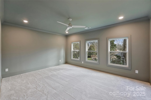 empty room with ceiling fan, ornamental molding, and light colored carpet